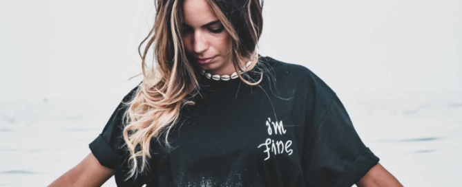 Young girl wearing a black shirt and standing in water.